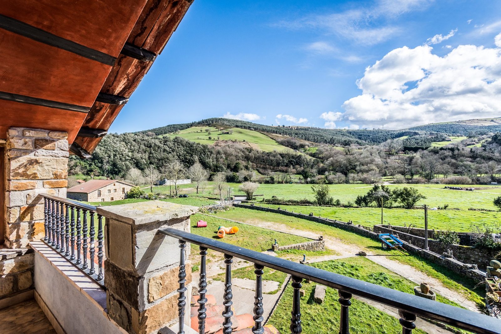 Vistas desde el balcón de Finca Gándara al valle verde de Cantabria en un día soleado